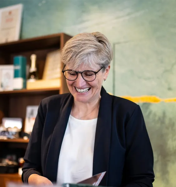 Elisabeth Zenz lächelt beim Kundengespräch – im Hintergrund eine Vitrine mit Uhren
