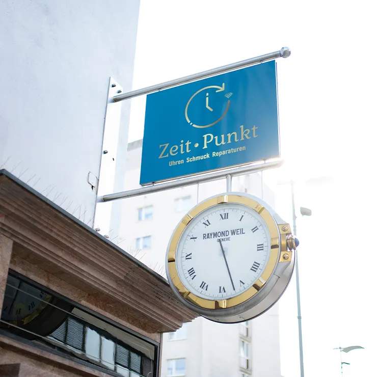 Firmenschild und Uhr des Juweliers Zeit-Punkt an der Außenfassade in Wr. Neustadt